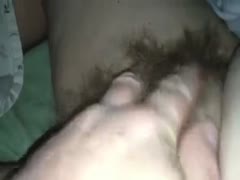 Facing a camera while stroking my wife's hirsute snatch